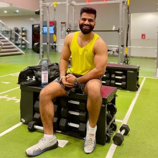 Gaurav Chaudhary (technical guruji) is posing in gym with a yellow dress