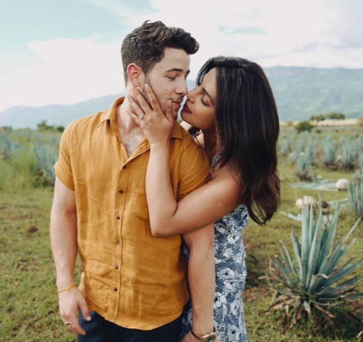 Priyanka Chopra Nick Jonas kissing pose in a scenic background
