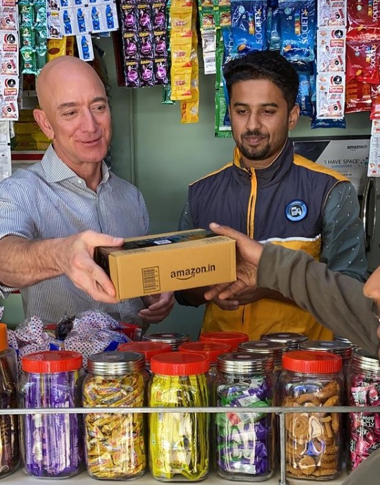 Jeff Bezos taking Amazon delivery in an Indian small shop